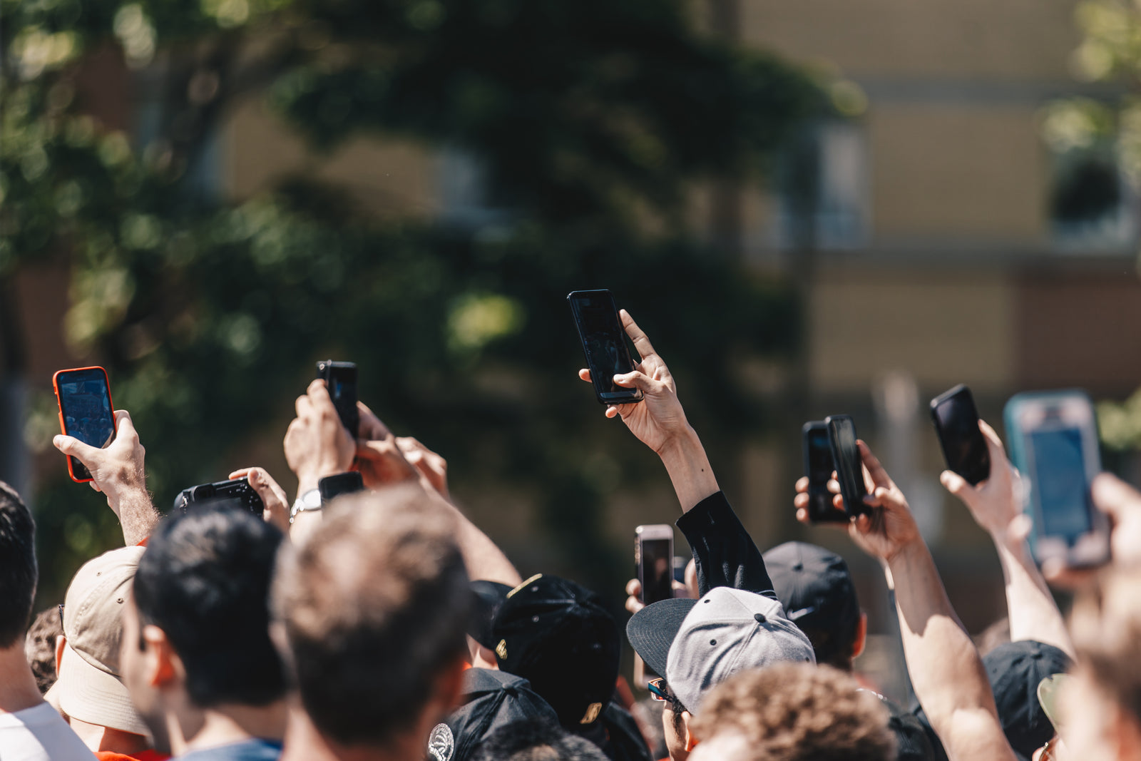 A crowd in the street holding up mobile phones to record