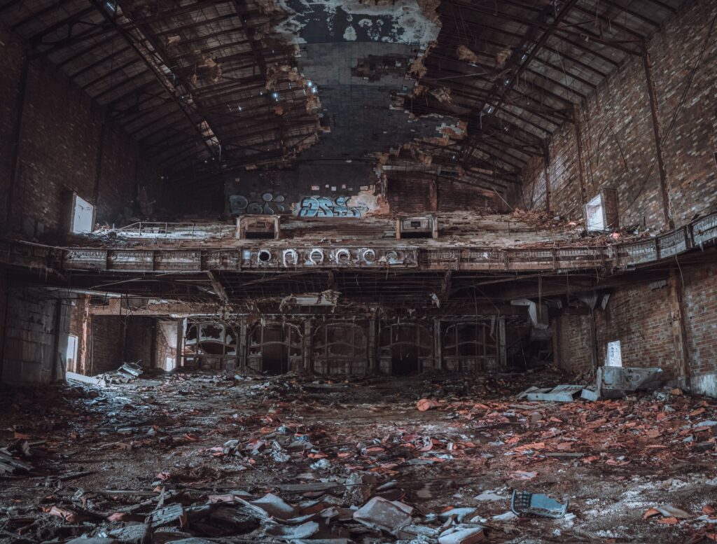A derelict hall with a collapsed ceiling and rubble across the floor