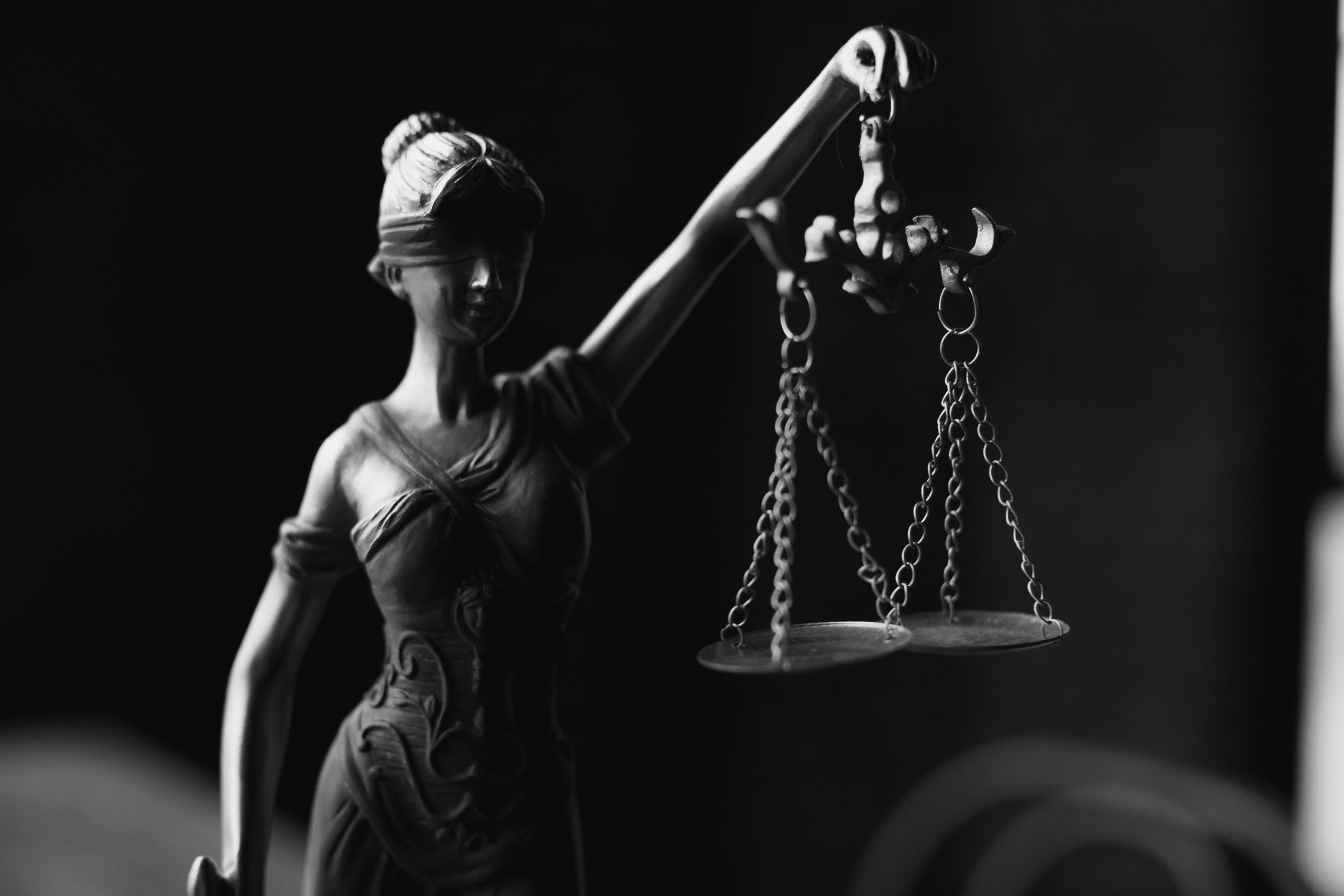Black and white statue of Lady Justice holding scales